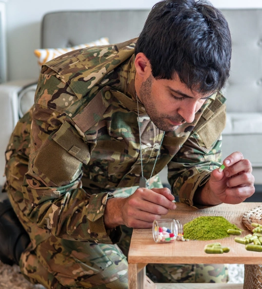 Depressed veteran soldier kneeling on the floor looking at Kratom