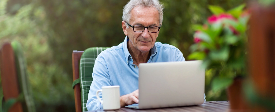Image of Veteran using a laptop to register for the VA Foreign Medical Program while living abroad