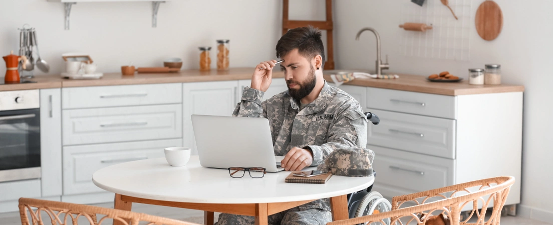 Image of a military service member using a laptop, representing the evaluation of eligibility for armed forces and moral waivers for drug-related offenses